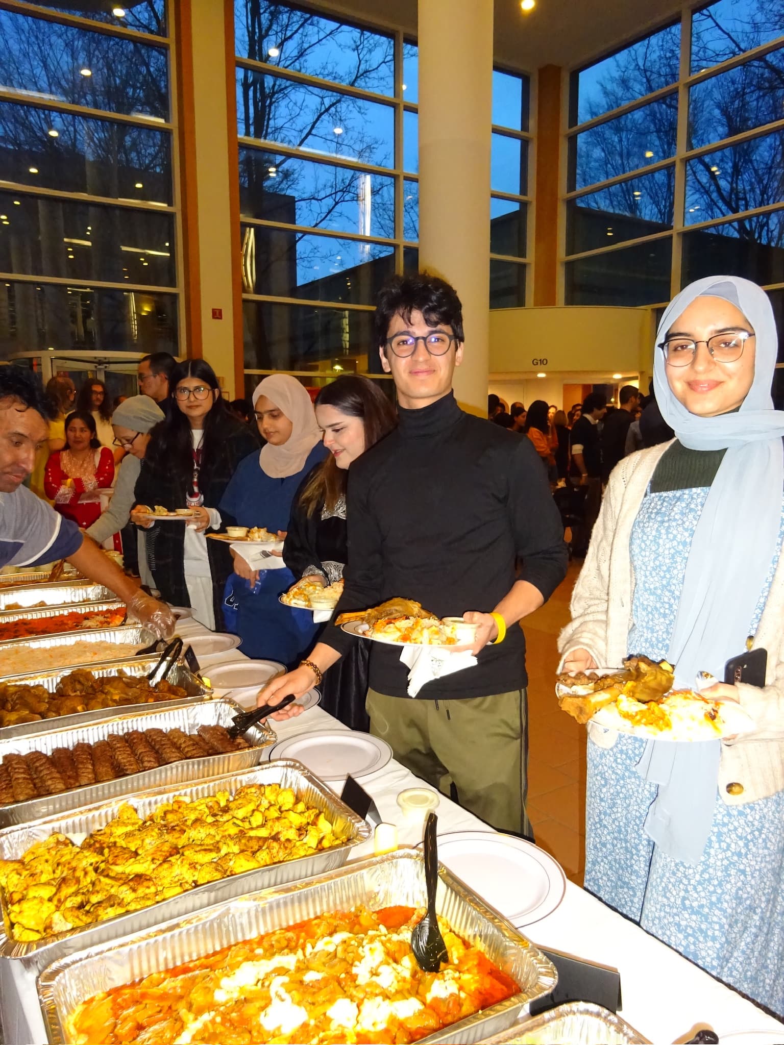 Students serving food during an OFAS community dinner.